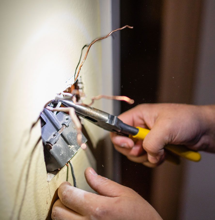 Electrician in mounting electric sockets on the wall