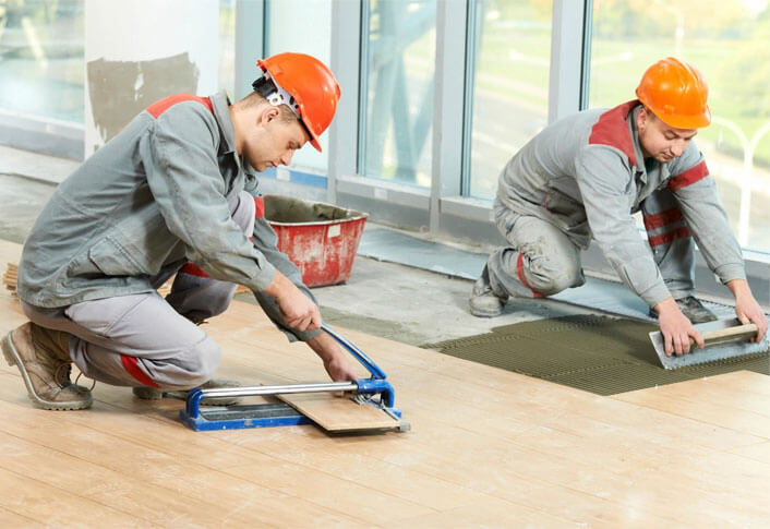 Two tilers at industrial floor tiling renovation