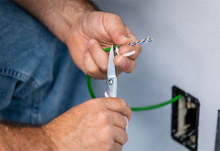 Electrician cuts electrical wires with pliers,